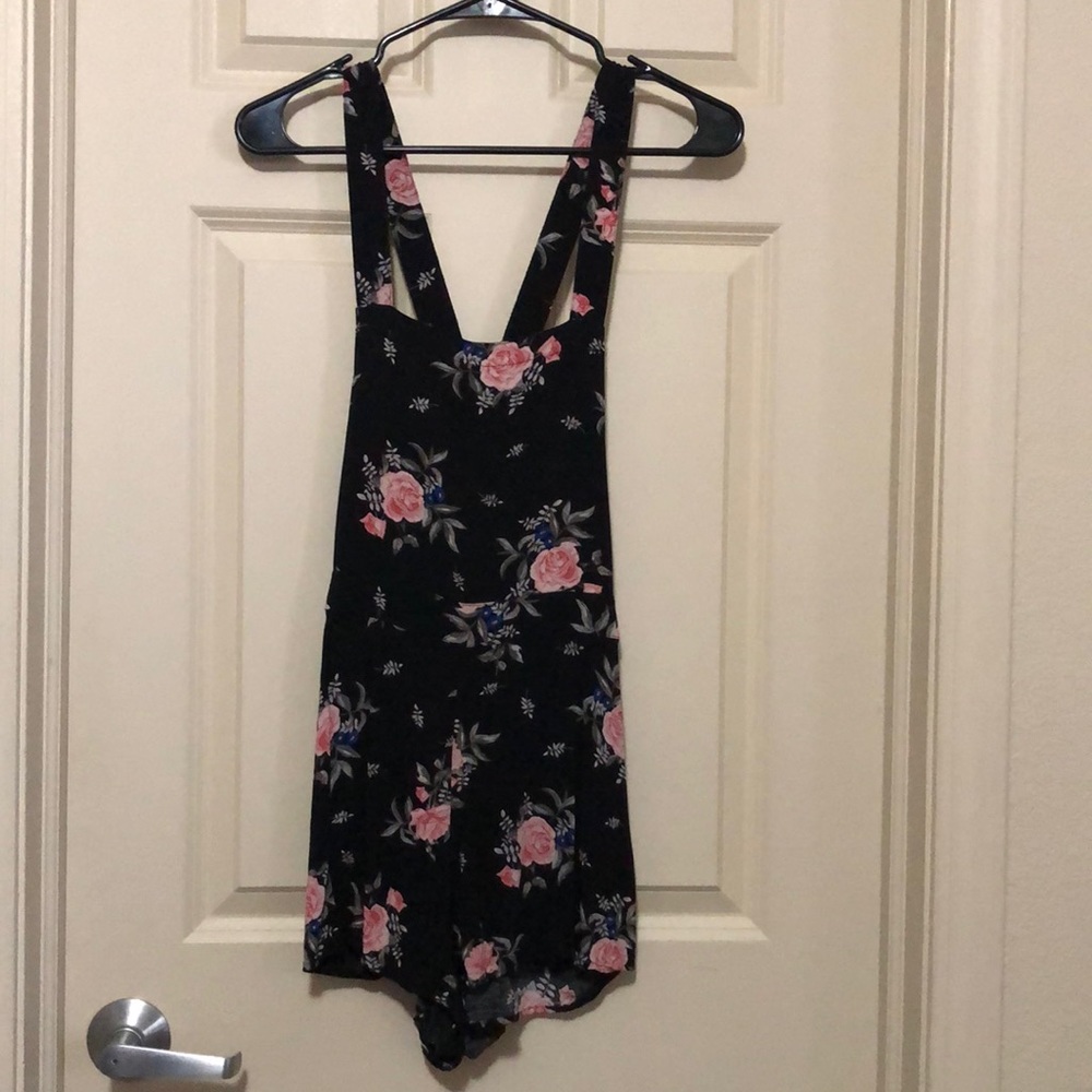 Black overalls with pink and blue flowers and green/gray leaves.